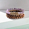 A set of four bracelets made of amethyst, rhodonite, wooden beads and metal