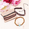 Set of four fashionable imitation leather bracelets and wood peace sign