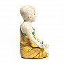 Buddhist monk statuette of a boy in a yellow robe colored