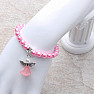 Children&#39;s bracelet made of pink glass beads with an angel